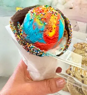 Rainbow ice cream in a dipped cone