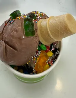 Chocolate ice cream with candy and a cone