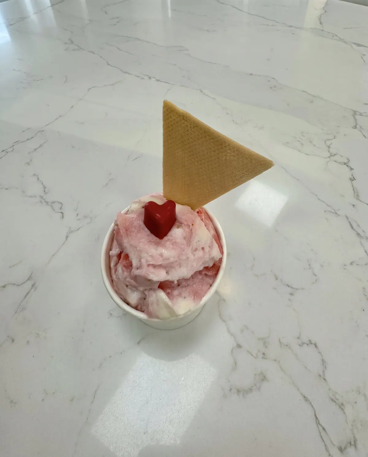 Strawberry gelato with a heart and a wafer